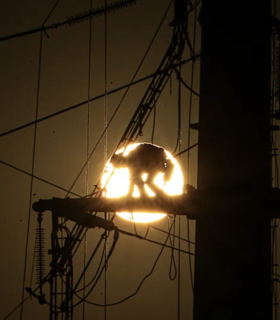 Infraestructura eléctrica con líneas de alta tensión durante puesta de sol